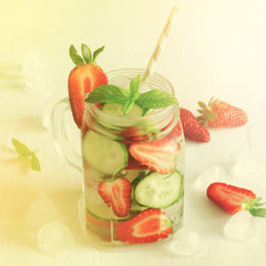 Summer refreshing iced drinks with orange, lemon, cucumber and strawberry on white background