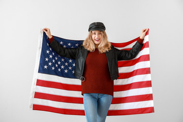 Young woman with USA flag on light background. Memorial Day celebration