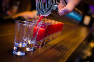 Set of red shots on bar counter