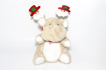 Cute teddy hippo, soft toy with christmas decoration of santa on a head on white background