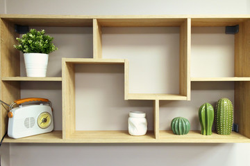 Home interior decoration, wooden wall shelf with objects composition- vase, decorative elements...