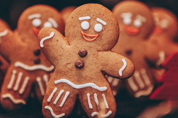 Many Christmas cookies in the form of gingerbread men depicting people celebrating the New Year in the forest near the Christmas tree