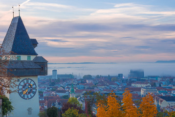 Cityscape of Graz and the famous clock tower (Grazer Uhrturm) on Shlossberg hill, Graz, Styria region, Austria, in autumn, at sunrise