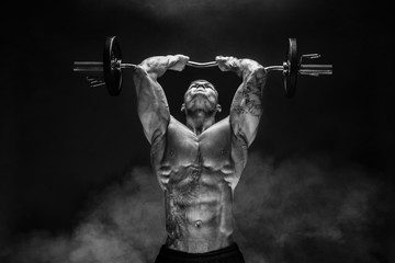 Fototapeta na wymiar Portrait of muscular man lifting dumbbell. Studio shot. Exercise for triceps. Motivation.