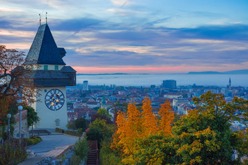 Cityscape of Graz and the famous clock tower (Grazer Uhrturm) on Shlossberg hill, Graz, Styria region, Austria, in autumn, at sunrise