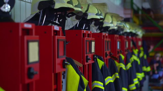 Firefighter uniforms hanging in row in fire station