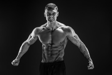Fototapeta na wymiar Very brawny guy bodybuilder posing. Beautiful sporty guy male power. Fitness muscled man. Roar