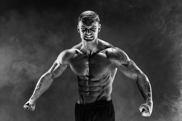 Very brawny guy bodybuilder posing. Beautiful sporty guy male power. Fitness muscled man. Roar....