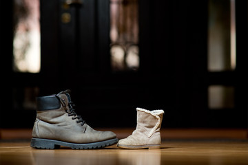 old adult leather shoes stand in front of children's shoes