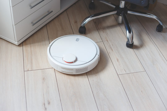 Robot Vacuum Cleaner Vacuuming Floor In Office