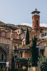 Fototapeta na wymiar 01.06.2019 Tbilisi, Georgia: view of old stone houses with beautiful colored roofs in the center of the old town where tourists are walking