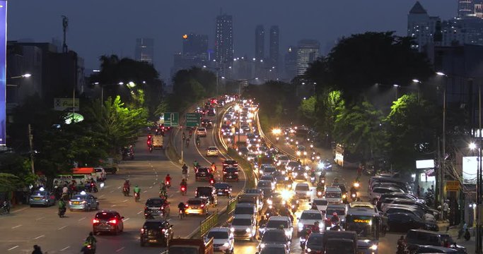 JAKARTA, Indonesia - November 27, 2019: Beautiful aerial view of traffic jam at night with numerous vehicles and light trails on highway. Shot in 4k resolution from a drone