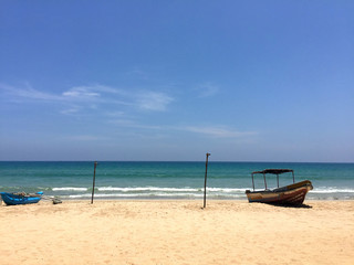  view from the beach to the ocean. Fishing boats on the shore and the complete absence of people. Sri Lanka, Trincomalee is unusually beautiful, green island