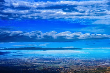  Aerial view of city at foot of green hills