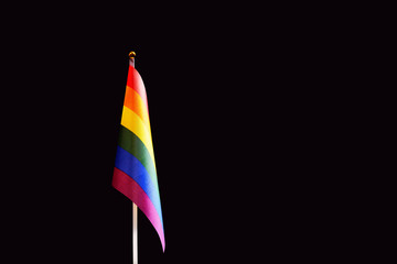 LGBT flag in rainbow colors. Black background. The concept of love, independence and freedom for gay people, homosexuals, lesbians and other sexual minorities. Copy space.