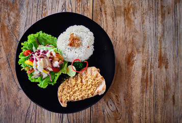 Grilled tuna steak with rice and vegetables on a wooden table. Top view. Image with place for text.