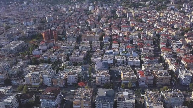 Aerial view of a beautiful city under the light of the summer sun. Art. Flying over the modern city with houses and buildings, streets and trees.