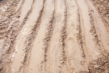 Naklejka premium Sand texture at a construction site. Traces of wheels.
