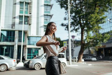 girl joyfully dances snapping fingers bent at the elbow of her hand on a city street