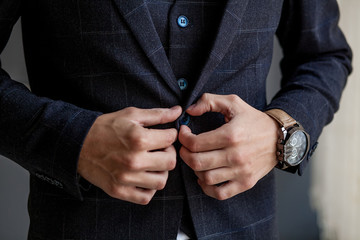 Man gets ready for work by buttoning up his business shirt. Groom's morning preparation before wedding