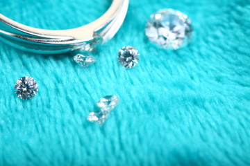 Close up shoot of an white gold engagement ring with diamonds on an isolated green background