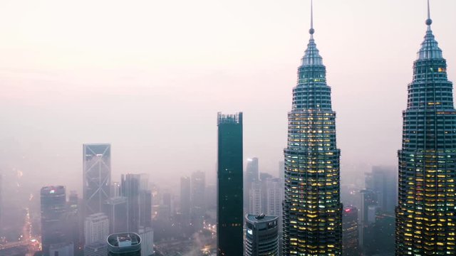 KUALA LUMPUR, Malaysia - November 28, 2019: Stunning aerial view of Petronas Twin Towers and other skyscrapers on misty morning. Shot in 4k resolution from a drone flying forwards