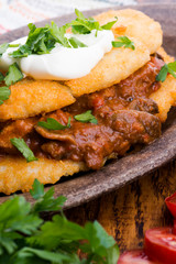 Potato pancakes with meat, vegetable, tomato and parsley