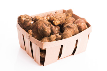Raw Whole ans sliced Jerusalem artichokes on a white background