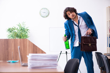 Young drunk employee in the office