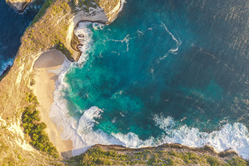 Aerial view of the Kelingking Beach aka Manta Bay with the amazing big wave and blue ocean located in Nusa Penida, Bali, Indonesia.