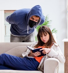The armed man assaulting young woman at home