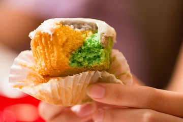 Multi colored cupcake being eaten