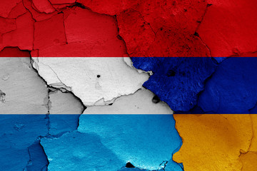 flags of Luxembourg and Armenia painted on cracked wall