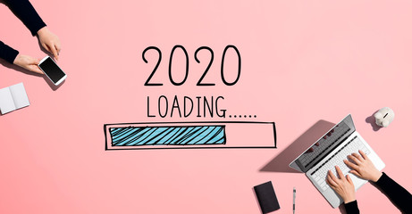 Loading new year 2020 with people working together with laptop and phone