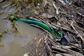 Plastic from water and soda bottles, a fast food container and a kayak litter the Cumberland river...