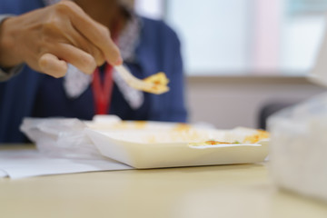 Obraz na płótnie Canvas Woman in office uniform eating Thai food