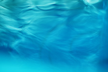 The smooth natural blue water background with bokeh  abstract on the sea or ocean,vintage and soft colored blur.