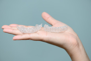 Woman show orthodontic silicone trainer. Mobile orthodontic appliance for dental correction. tooth...