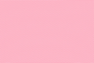Light pink background from a textile material with pattern, closeup. Perforated cloth backdrop.