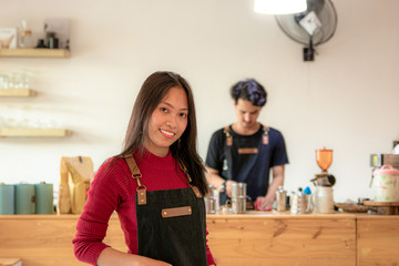 Couple of Asian barista are working in coffee shop.