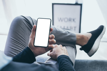 Mockup image blank white screen cell phone.men hand holding texting using mobile on desk at home office. background empty space for advertise text.people contact marketing business and technology 