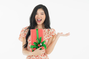 Photo of asian curious woman in red dress rejoicing her birthday or new year gift box. Young woman holding gift  box with red bow being excited and surprised  holiday.