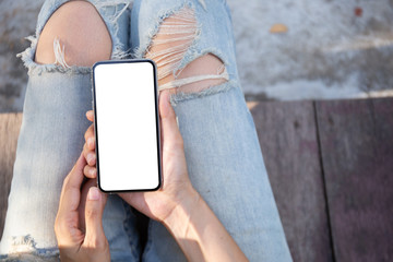 Mockup image blank white screen cell phone.men hand holding texting using mobile sitting in park.background empty space for advertise text.people contact marketing business and technology 