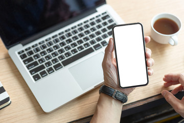 Mockup image blank white screen cell phone.men hand holding texting using mobile on desk at home office. background empty space for advertise text.people contact marketing business and technology 