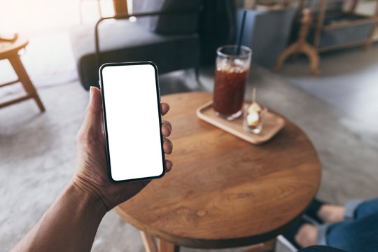 Mockup image blank white screen cell phone.men hand holding texting using mobile on desk at home office. background empty space for advertise text.people contact marketing business and technology 