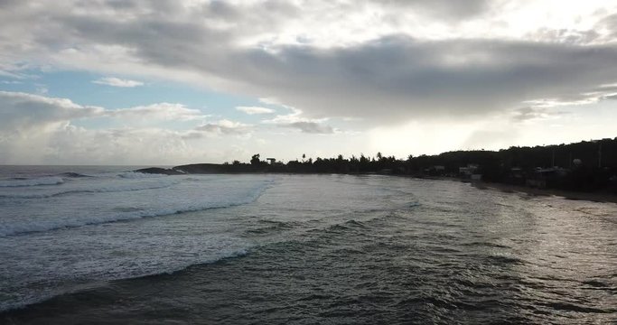 Drone flying over beach water with crashing waves in Jobos Puerto Rico