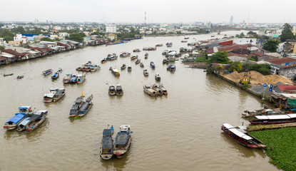 Fototapeta na wymiar Cai Rang Floating Market on the Mekong River in the morning from aerial perspective featuring the river boats