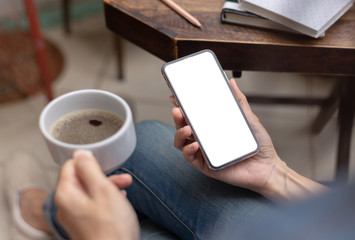 Mockup image blank white screen cell phone.men hand holding texting using mobile on desk at home office. background empty space for advertise text.people contact marketing business and technology 