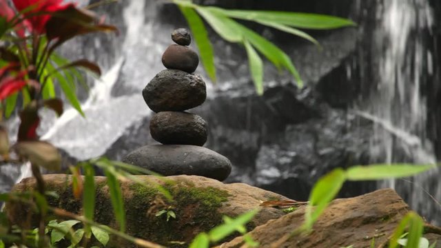 stack of balancing stones with waterfall stream in background in bali