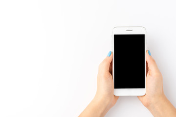 Overhead shot of female hands using smart phone with empty screen isolated on white background. Top view